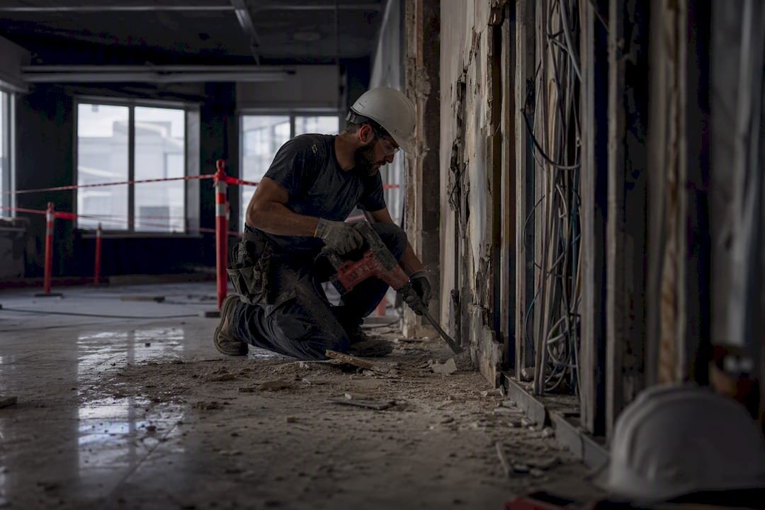 Worker stripping building interior wall