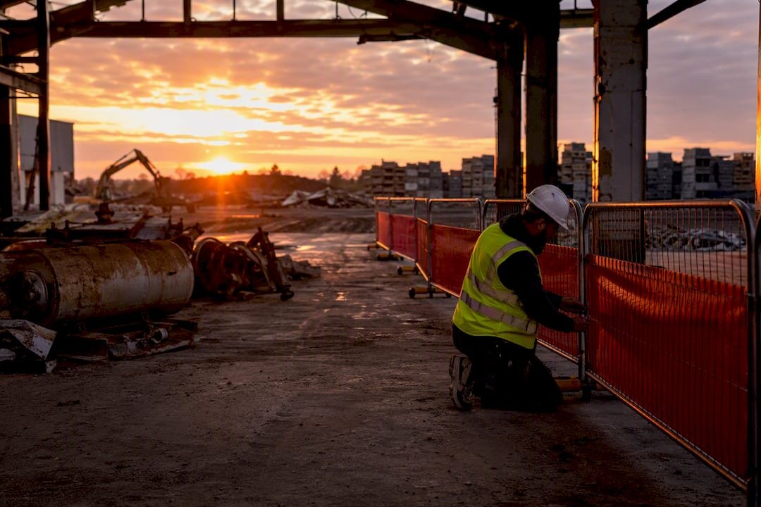 Contractor installing safety barriers at demolition site
