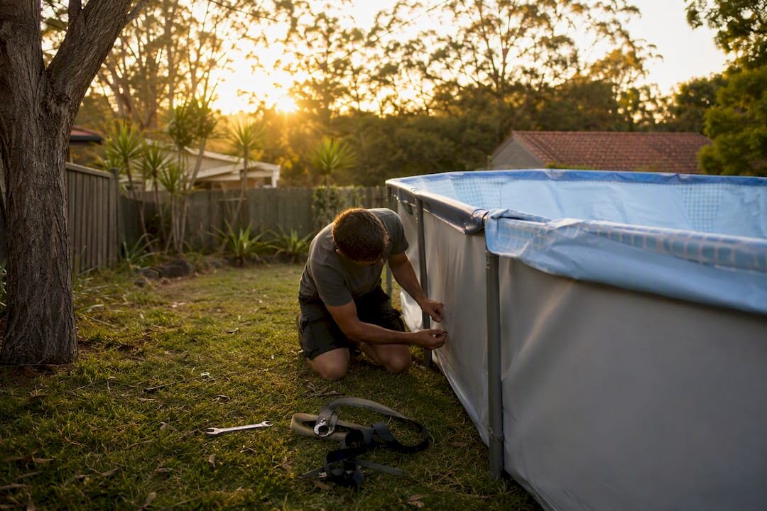 Hands dismantling above-ground pool frame