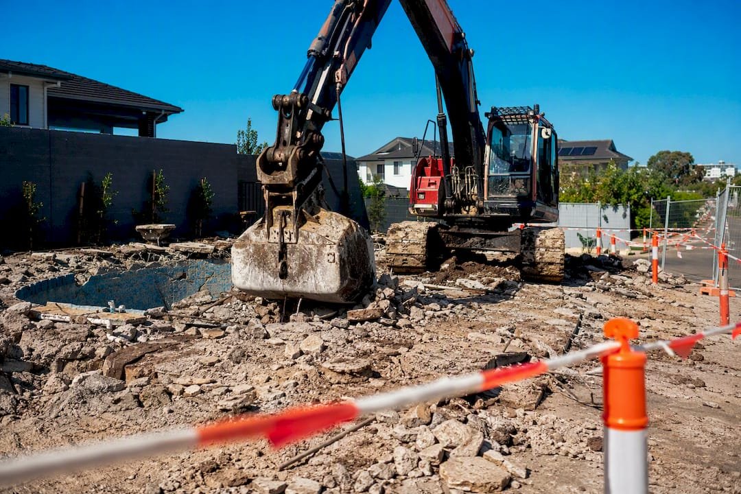 Excavator and rubble at pool removal site