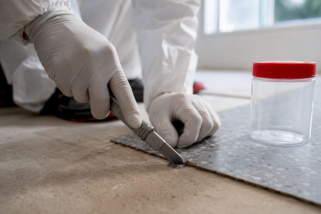 Licensed assessor sampling old flooring