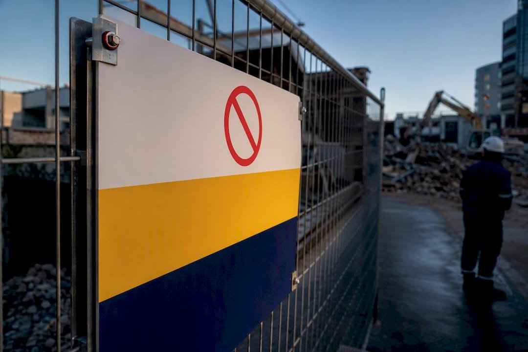 Safety sign fixed to demolition site fencing