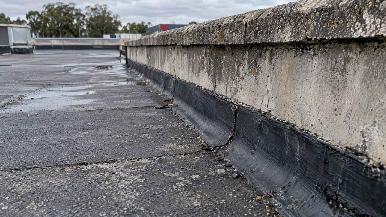Black bituminous membrane at a commercial roof edge